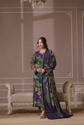A woman standing in a beautifully decorated room wearing a traditional, digitally printed shawl with a floral design in shades of purple and blue.