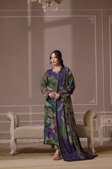 A woman standing in a beautifully decorated room wearing a traditional, digitally printed shawl with a floral design in shades of purple and blue.