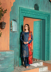 A woman wearing a lawn digital printed blue and red dress with chiffon dupatta, standing against a turquoise background.